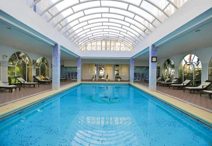 Piscine couverte du Paradis Palace avec des chaises longues